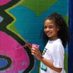 A girl painting on a wall